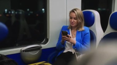 Woman in business suit with phone travelling by the train.