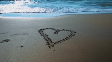 Heart drawn on the sandy sea beach.
