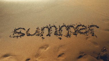 Word Summer drawn on the sandy sea beach.