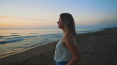 Man cover woman with blanket and hugging on the beach at sunset.