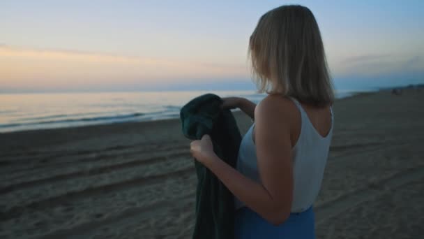 Mujer Arroja Una Manta Sobre Misma Atardecer Junto Mar — Vídeo de stock