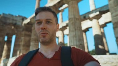 Male tourist shows and talks about the old temple.