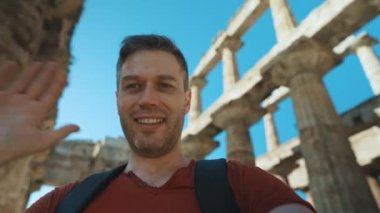 Male tourist shows and talks about the old temple.