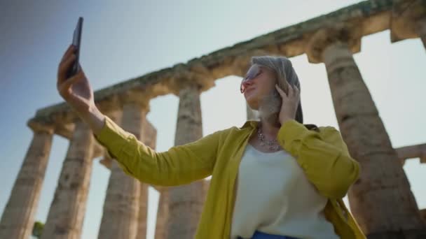 女性は 古代寺院の遺跡の前で自撮り — ストック動画
