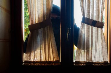 Kar maskeli hırsız pencereden içeri bakıyor..