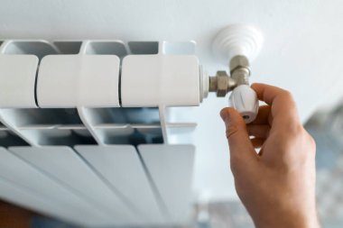 Erkek el termostat radyatör evde ısıtıcıyı ayarlama.