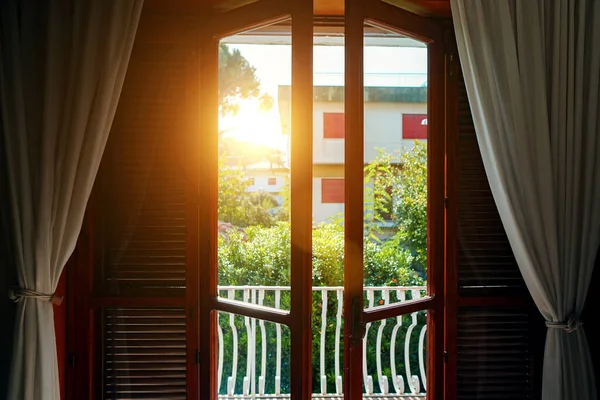 Open balcony door with garden view.
