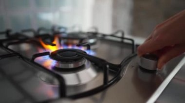 Kadın ocağın gaz ocağını açıyor..