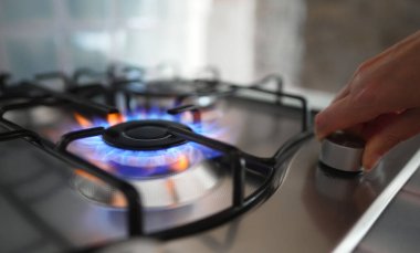 Kadın ocağın gaz ocağını açıyor..