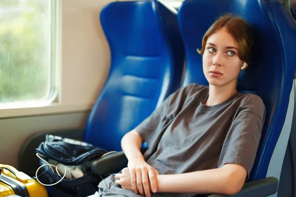 带着耳机在火车上旅行的少女 — 图库照片
