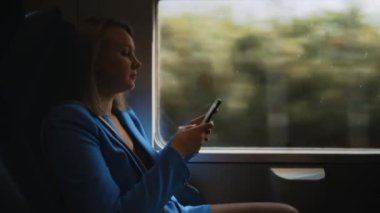 Trenle seyahat eden takım elbiseli bir kadın..