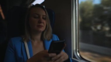 Trenle seyahat eden takım elbiseli bir kadın..