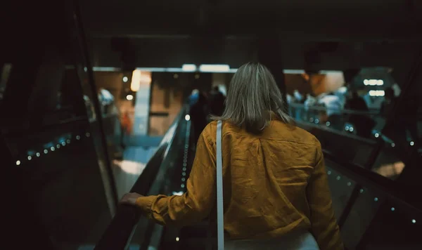 乘地铁自动扶梯的女人 — 图库照片