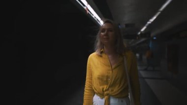Woman is waiting for the train in the subway.
