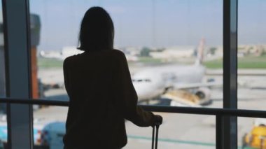 Teenage girl is waiting for her flight at the airport.