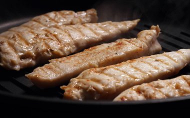 Tavuk fileto parçaları ızgarada kızartılır..