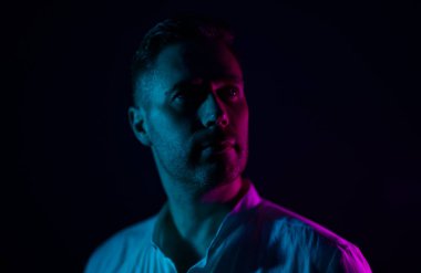 Tıraşsız, orta yaşlı yakışıklı bir adamın portresi. Neon ışıklarıyla.