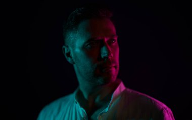 Tıraşsız, orta yaşlı yakışıklı bir adamın portresi. Neon ışıklarıyla.