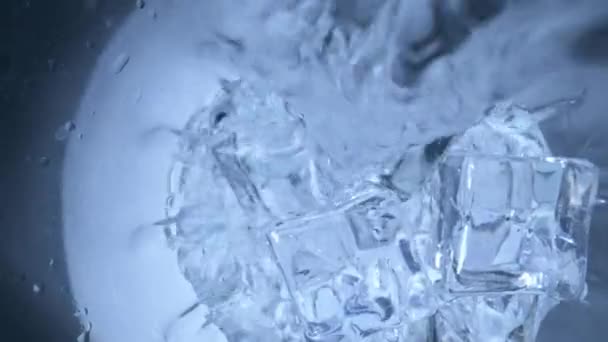 把水倒入装有冰块的杯子里 — 图库视频影像