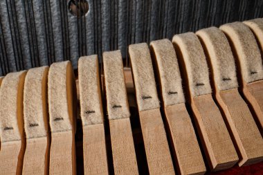 Piyanonun içinde. Dik piyanonun içindeki çekiçlerin ve tellerin yakın görüntüsü.