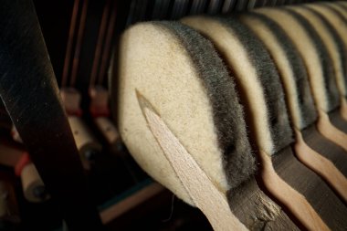 Piyanonun içinde. Dik piyanonun içindeki çekiçlerin ve tellerin yakın görüntüsü.