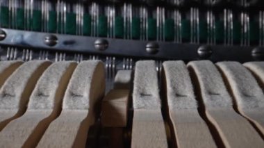 Piyanonun içinde. Dik piyanonun içindeki çekiçlerin ve tellerin yakın görüntüsü.