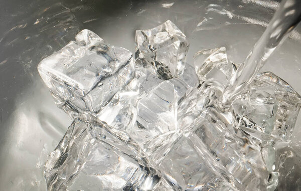 Вода наливается в стакан со льдом.
