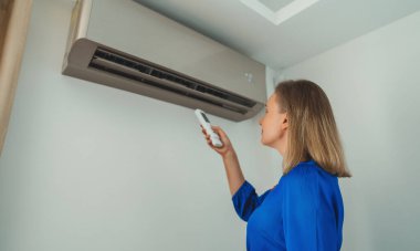 Uzaktan kumanda Klima havalandırma amaçlı tutan kadın.