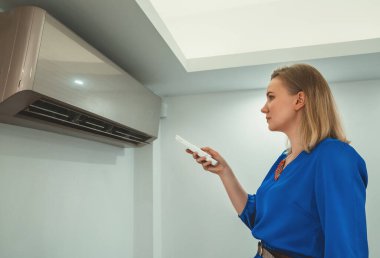 Uzaktan kumanda Klima havalandırma amaçlı tutan kadın.