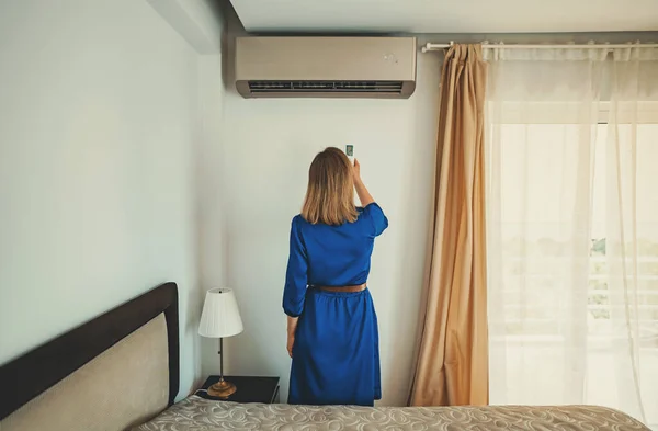 Woman Holding Remote Control Aimed Air Conditioner — Stock Photo, Image
