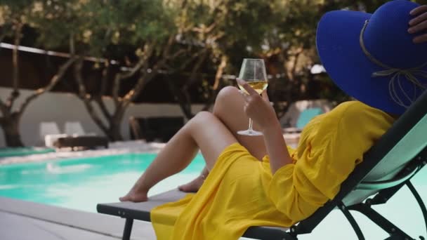 在游泳池边喝一杯白葡萄酒的女人放松一下 — 图库视频影像