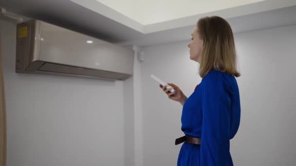 Vrouw Met Afstandsbediening Gericht Air Conditioner — Stockvideo