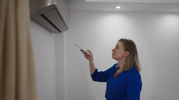 Woman Holding Remote Control Aimed Air Conditioner — Stock Video