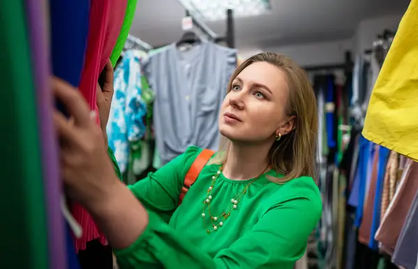 Woman choosing clothes in outlet store.