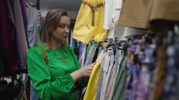 Kobieta Wybierająca Ubrania Sklepie Outlet — Wideo stockowe