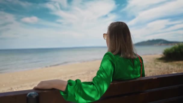 Kvinnan Grön Klänning Sitter Bänk Stranden — Stockvideo
