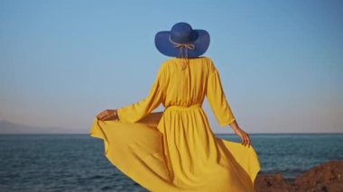 Okyanusa karşı sarı elbiseli kadın..
