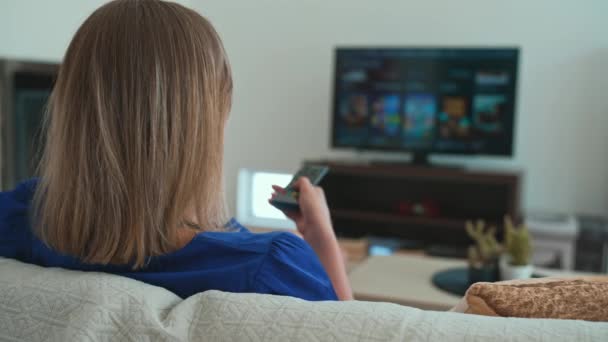女性は自宅で彼女のスマートテレビでコンテンツを見ます — ストック動画
