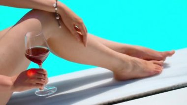 Havuzun kenarında bir bardak şarabı olan kadın..