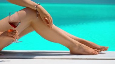 Havuzun kenarında bir bardak şarabı olan kadın..