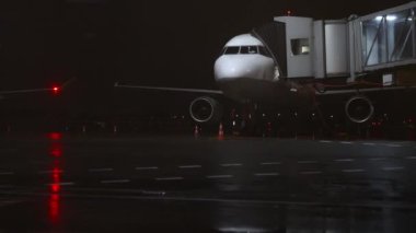 Geceleri havaalanında rampası olan bir uçak..