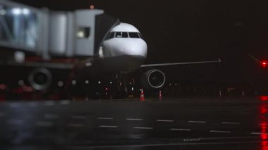 Geceleri havaalanında rampası olan bir uçak..