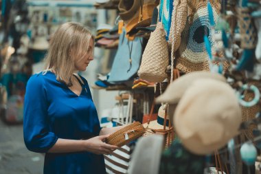 Akşam pazarında çanta seçen bir kadın..