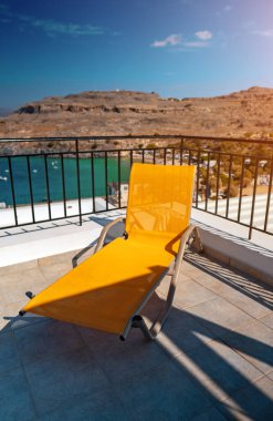 Sahile bakan balkondaki sarı güneş pansiyonunda..