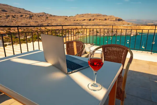 Laptop and a glass of wine. An ideal place for remote work.