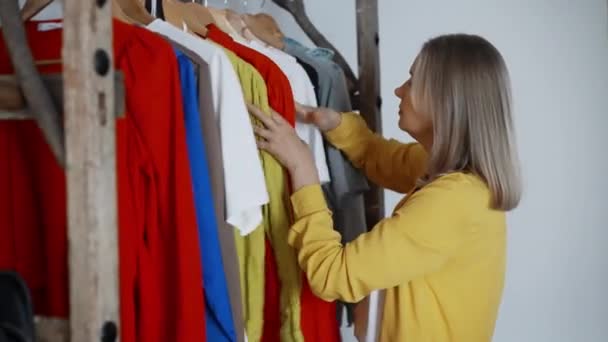 女性はワードローブの服から何を着るかを選択します — ストック動画