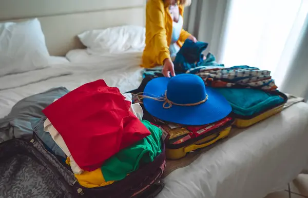 Woman packs her clothes into a suitcase. Preparing for vacation.
