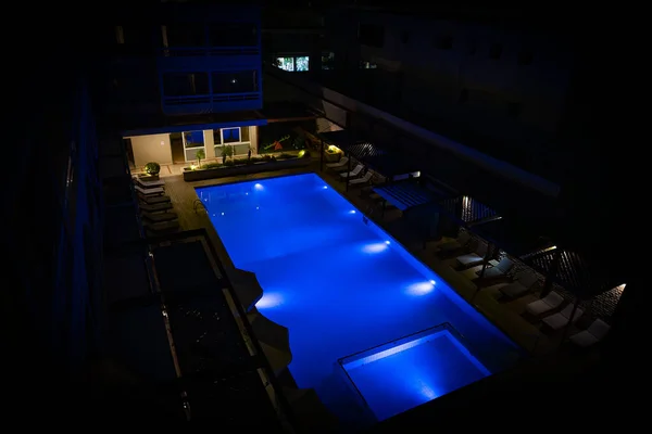 Modern backyard water pool at night.