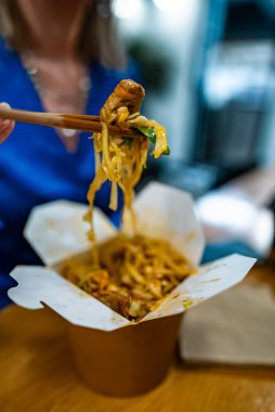 Sebzeli erişte yiyen bir kadın ve Çin 'den gelen et..