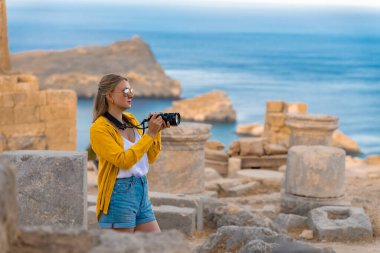 Akropolis 'te gezintiye çıkmış kameralı bir kadın turist..